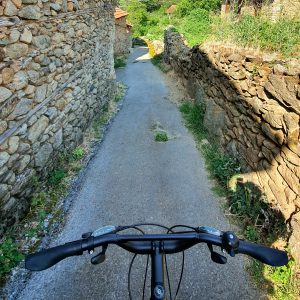 pov of cyclist riding in the village streets surrounded by centuries old stone houses