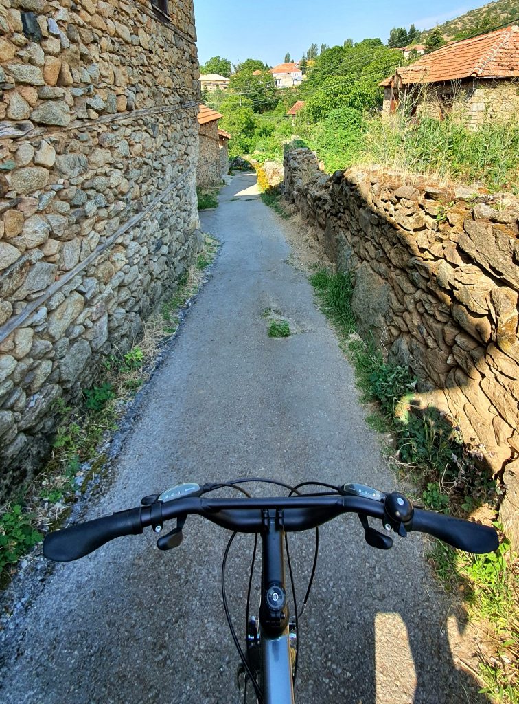 pov of cyclist riding in the village streets surrounded by centuries old stone houses